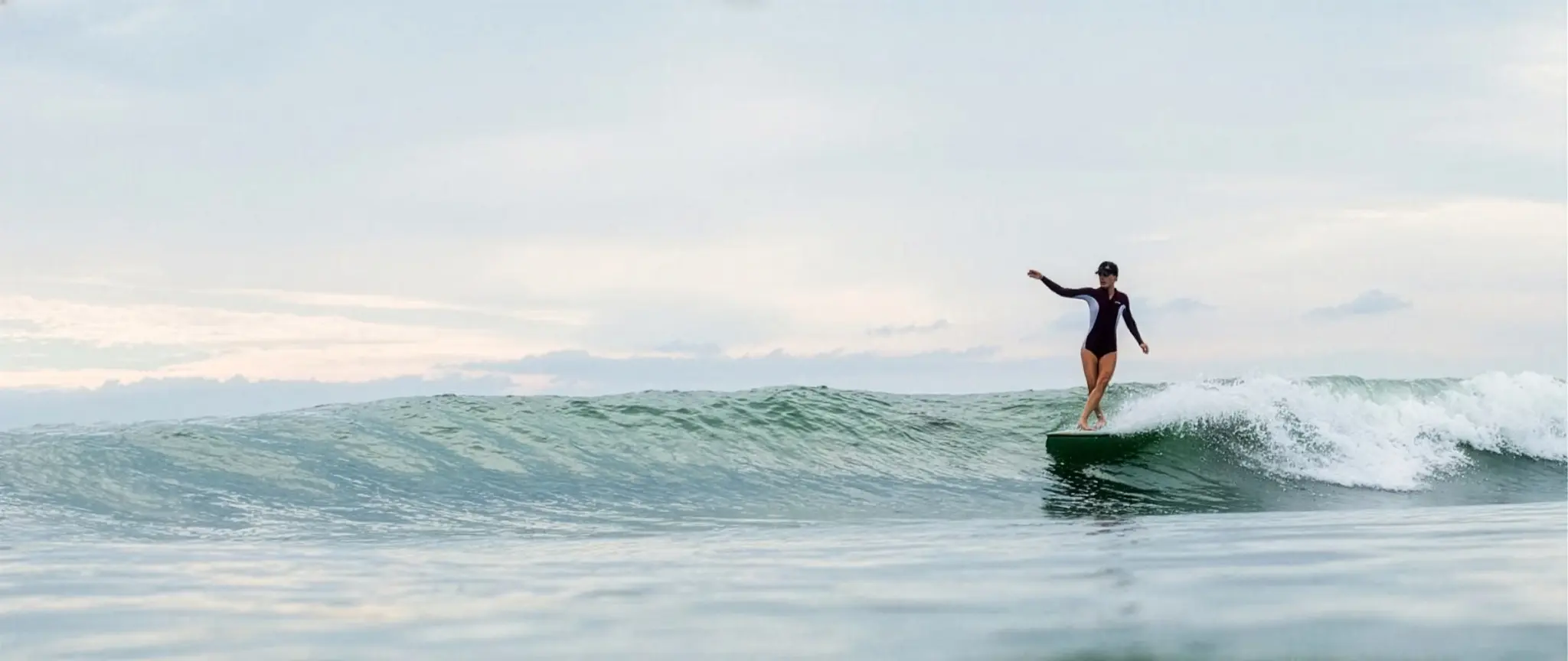 Surfeuse sur un longboard Utopik dans une vague bretonne